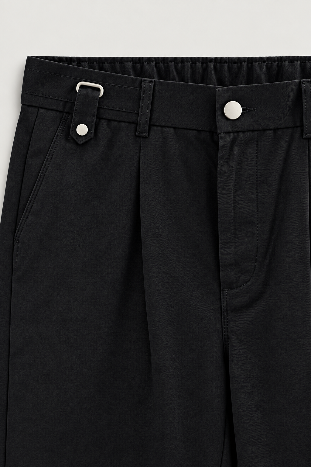 Pantalon à pinces à pattes de serrage noir, détail de la taille et de la patte de serrage